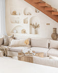 Modern boho living room with natural stone decor, neutral lounge seating, and wooden beaded necklace accents, creating a relaxed and stylish ambiance