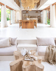 Modern boho living room with natural stone decor, neutral lounge seating, and wooden beaded necklace accents, creating a relaxed and stylish ambiance