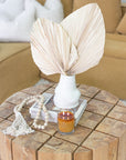 Natural wood bead garland with tassel, perfect for adding rustic charm and texture to home decor candle and vase.
