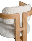 Contemporary wooden arm chair with a natural oak frame and boucle upholstered seat and backrest, designed for modern comfort and style