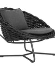 Round woven lounge chair in black with matching dark grey cushion, featuring a curved metal base for modern and stylish outdoor or indoor seating. Durable and comfortable design perfect for relaxed lounging