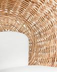 Natural wicker hanging egg chair with white cushion, suspended by a metal chain, perfect for indoor or outdoor relaxation