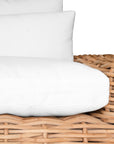 Natural wicker armchair with thick white cushions, showcasing a coastal-inspired design perfect for indoor and outdoor settings