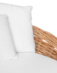 Natural wicker daybed with plush white cushions, creating a relaxed coastal vibe.