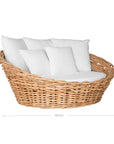 Natural wicker daybed with plush white cushions, creating a relaxed coastal vibe.