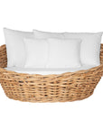 Natural wicker daybed with plush white cushions, creating a relaxed coastal vibe.