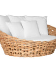 Natural wicker daybed with plush white cushions, creating a relaxed coastal vibe.