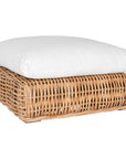 Natural wicker ottoman with a plush white cushion, creating a relaxed coastal vibe.