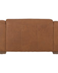 Modern leather upholstered armchair with soft, rounded cushions and light wooden legs