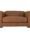 Modern leather upholstered armchair with soft, rounded cushions and light wooden legs