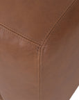 Modern leather upholstered sofa with soft, rounded cushions and light wooden legs