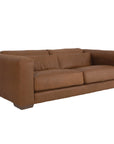 Modern leather upholstered sofa with soft, rounded cushions and light wooden legs