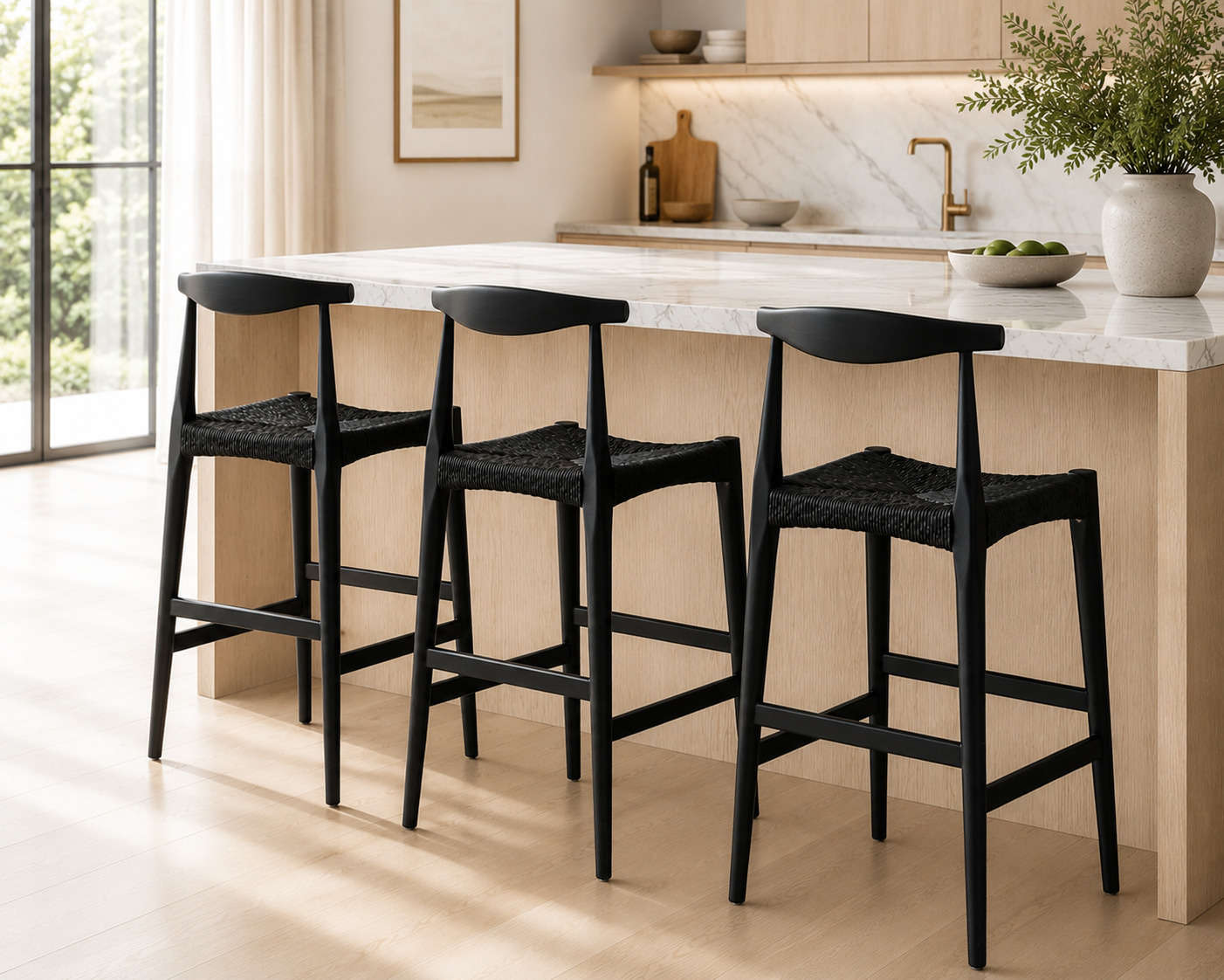 Black bar stools in a modern kitchen with marble countertop and wooden cabinets.