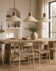 Dining room with wooden table and chairs, natural light, and decor elements.
