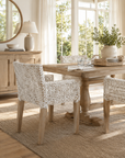 Dining room with wooden table and chairs, natural light, and decor elements.