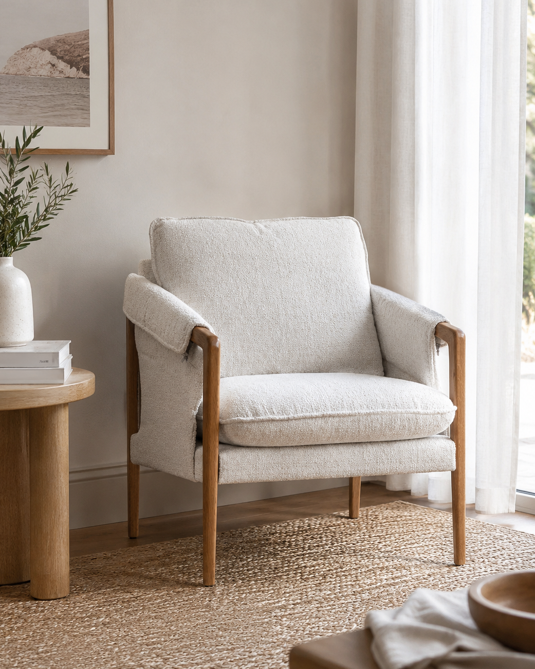 Beige armchair in a living room setting with a side table and decor items.