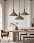 Modern dining room with wooden table, chairs, and pendant lights.