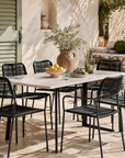 Outdoor dining set with a table and chairs on a patio.