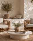 Outdoor patio with wicker chairs, stone table, and decorative elements.