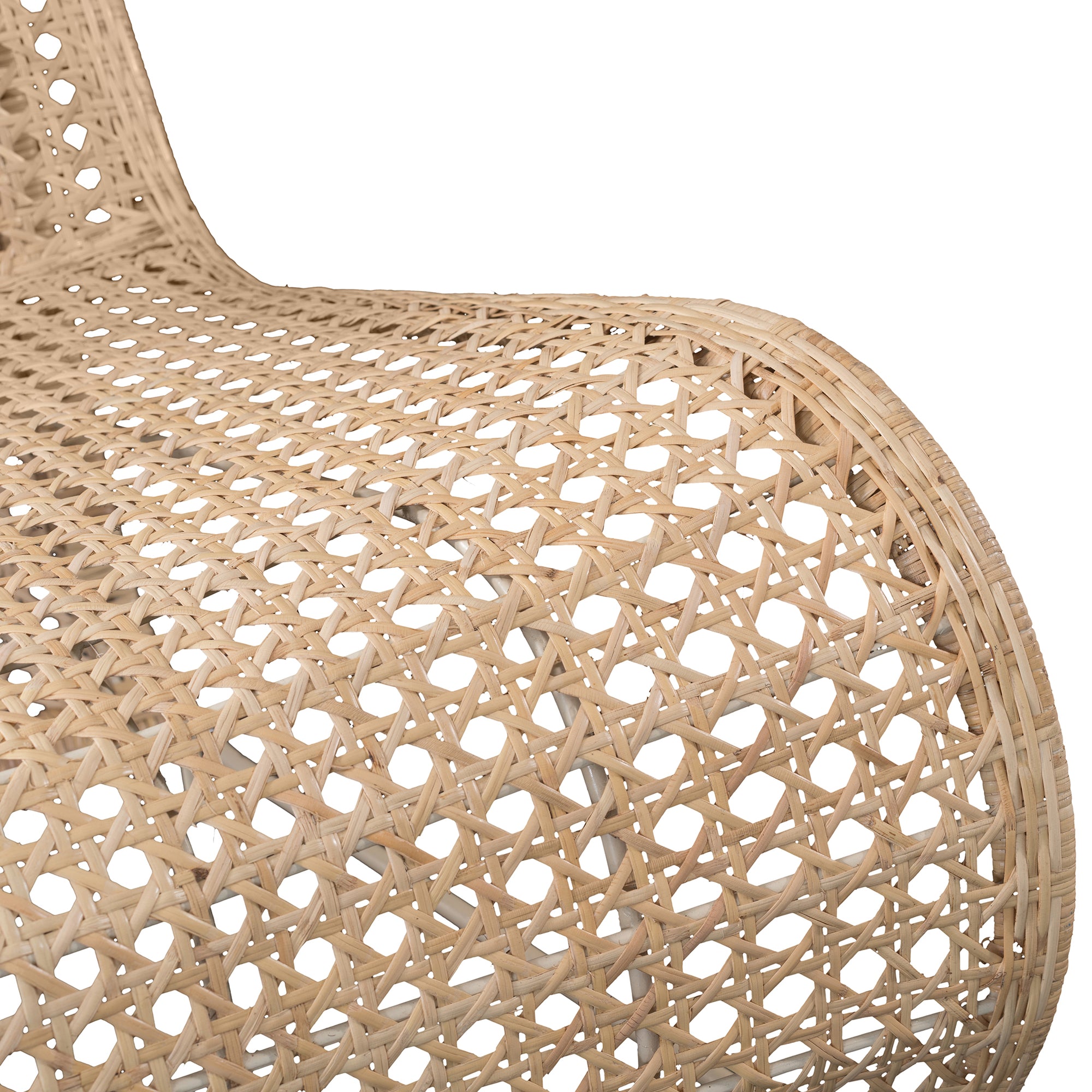 Modern coastal rattan lounge chair with curved silhouette and open weave pattern, featuring a natural finish and sleek white metal frame