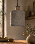 Textured pendant light hanging above a wooden table with rustic decor