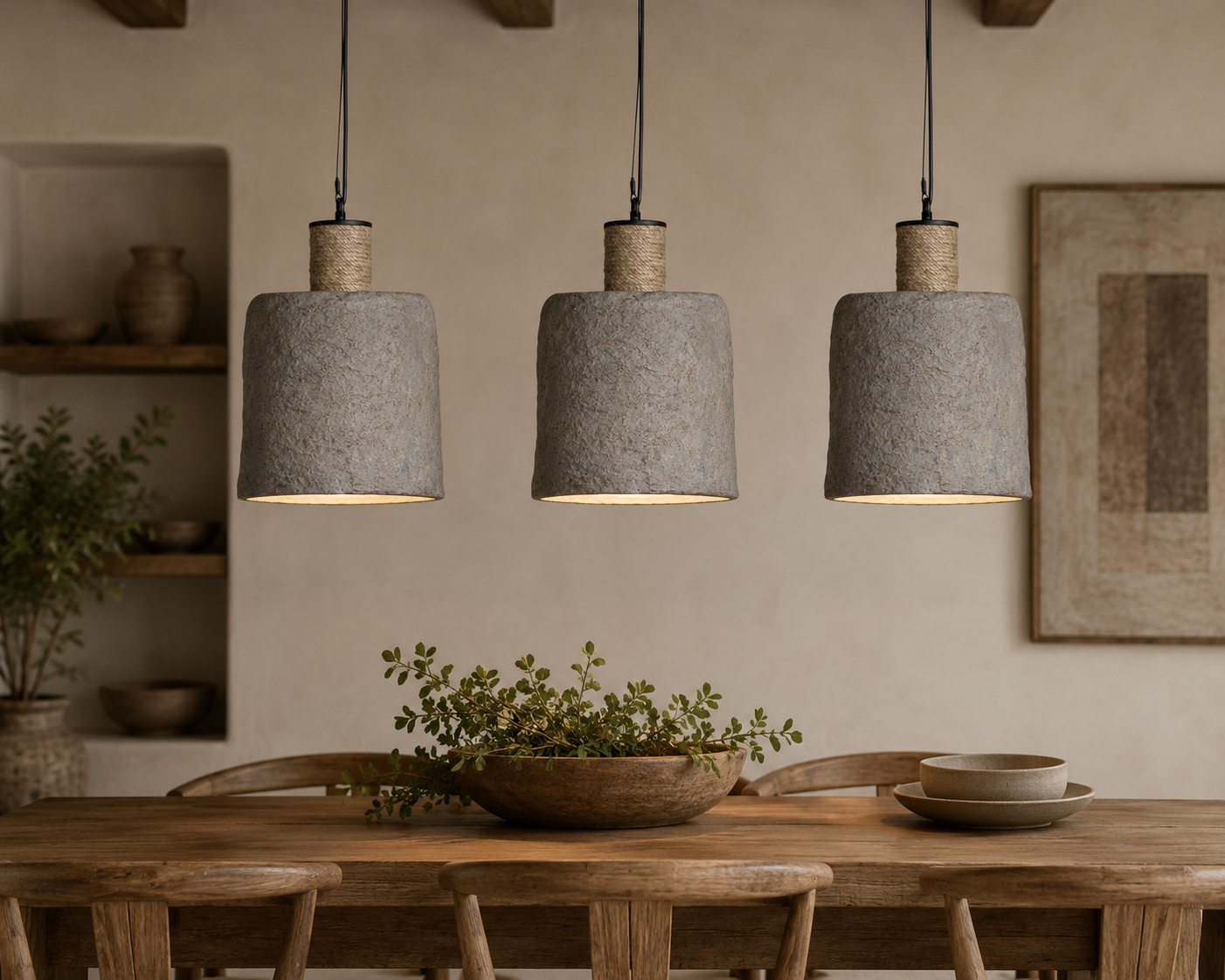 Three gray pendant lights hanging above a wooden dining table with plants and decor.