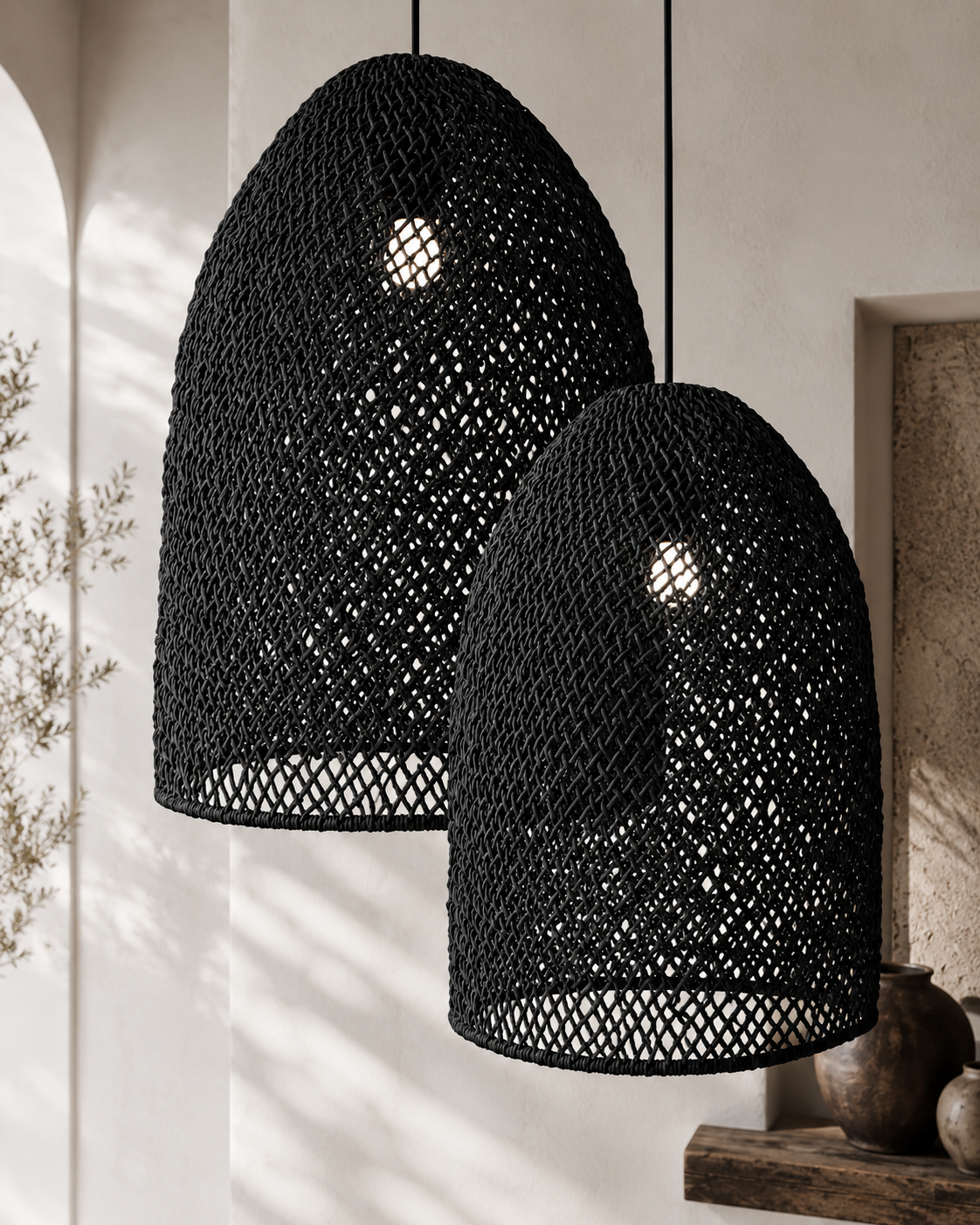 Two black woven pendant lights hanging against a neutral wall.
