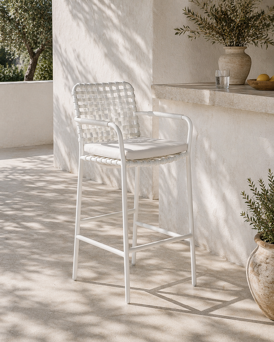 White outdoor chair on a patio with sunlight casting shadows