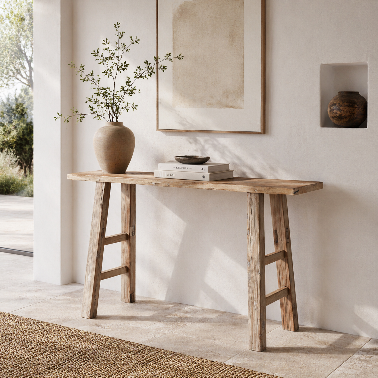Wooden console table with a vase and books against a white wall