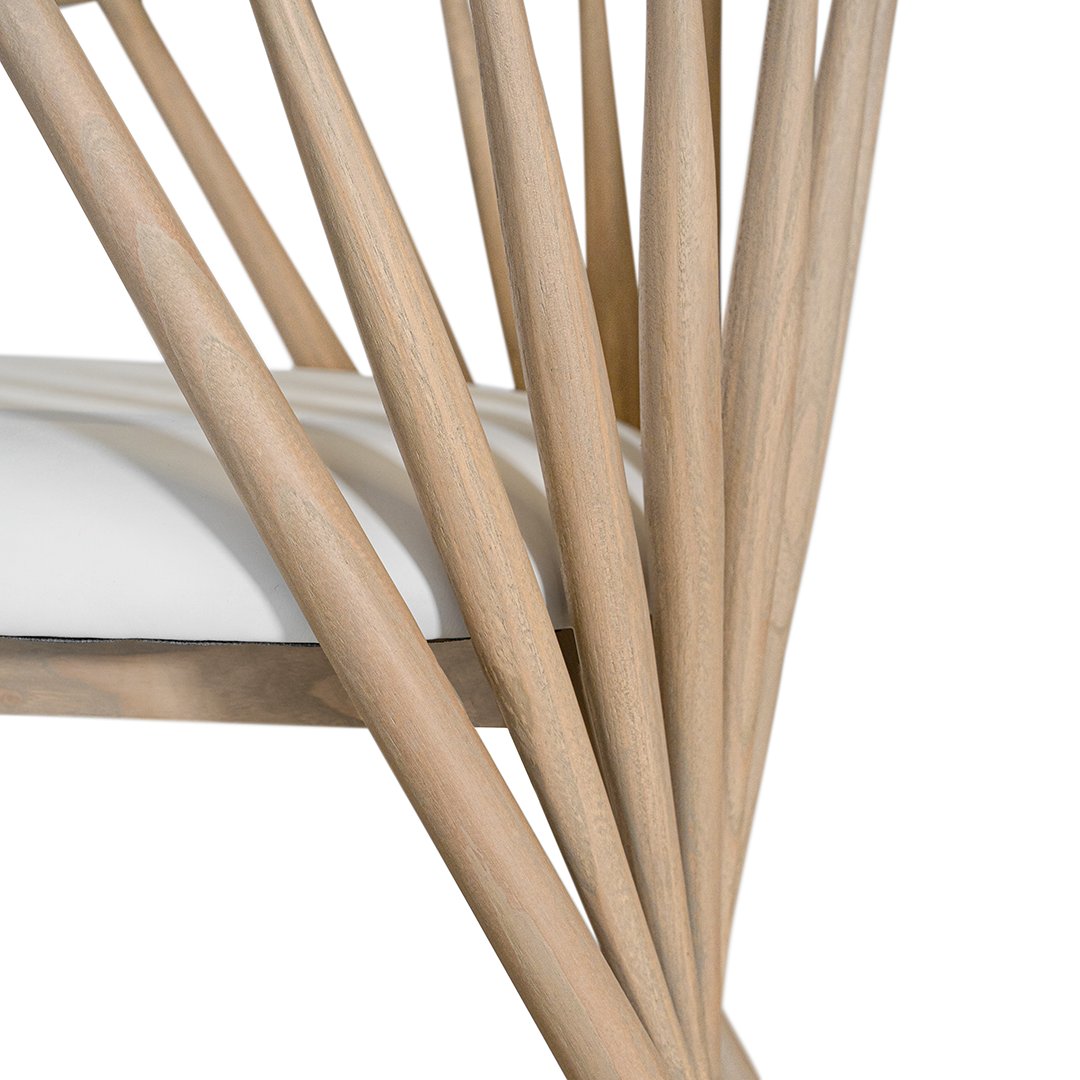 Lightwood spindle dining chair with a curved backrest and white upholstered seat, showcasing a modern yet timeless design. Crafted from solid wood, this chair brings a refined, natural aesthetic to any dining or living space