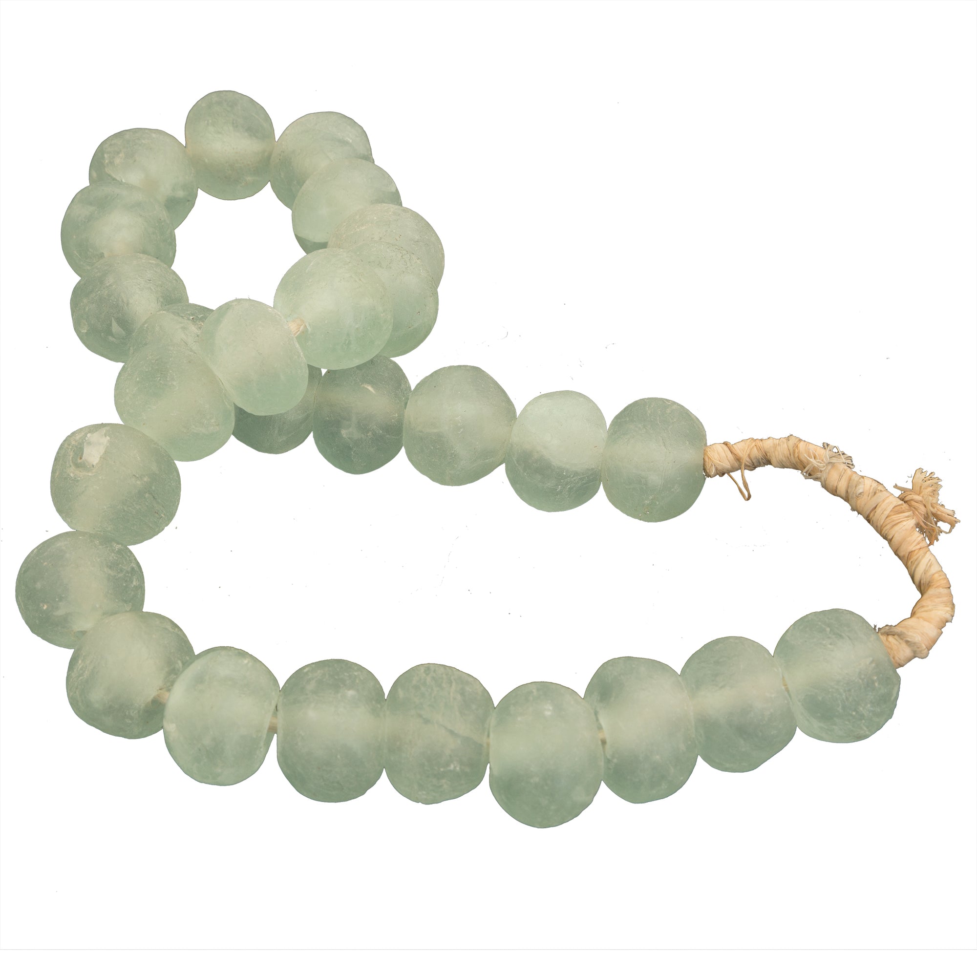 Decorative strand of recycled glass beads in a soft green hue, displayed on a minimalist black metal stand. A unique accent piece that adds texture and artisanal charm to any interior styling