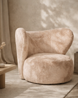Alli occasional chair in nougat with plush curved form styled in a soft textured living space with warm neutral tones.