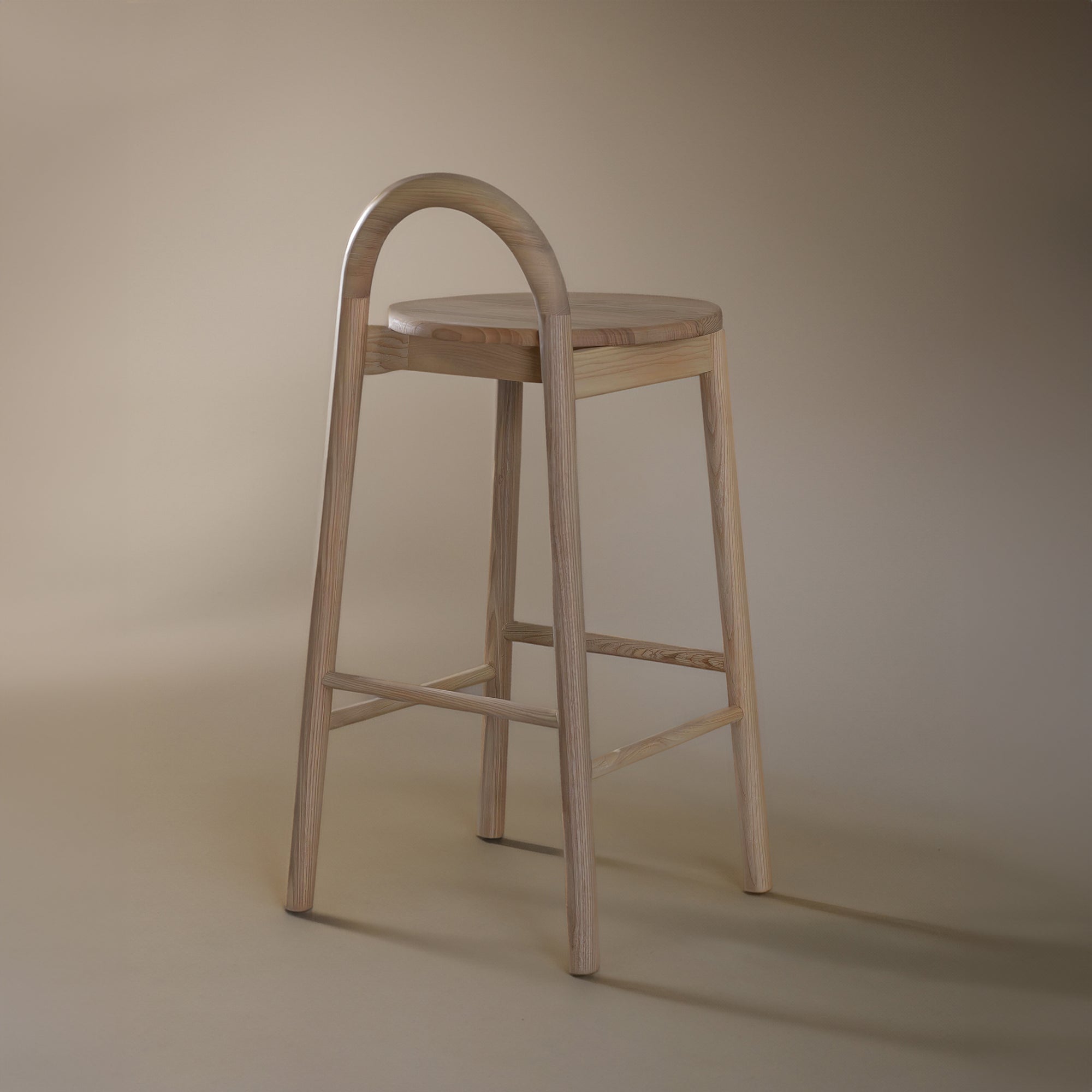 A minimalist solid ashwood bar stool with a curved backrest and natural finish, designed for modern kitchen and bar spaces