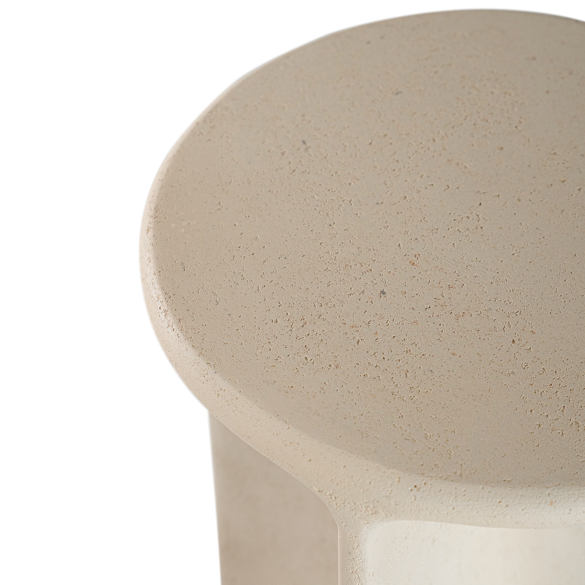 Berber side table in driftstone finish featuring sculptural curved legs and a softly rounded top with a textured natural surface.