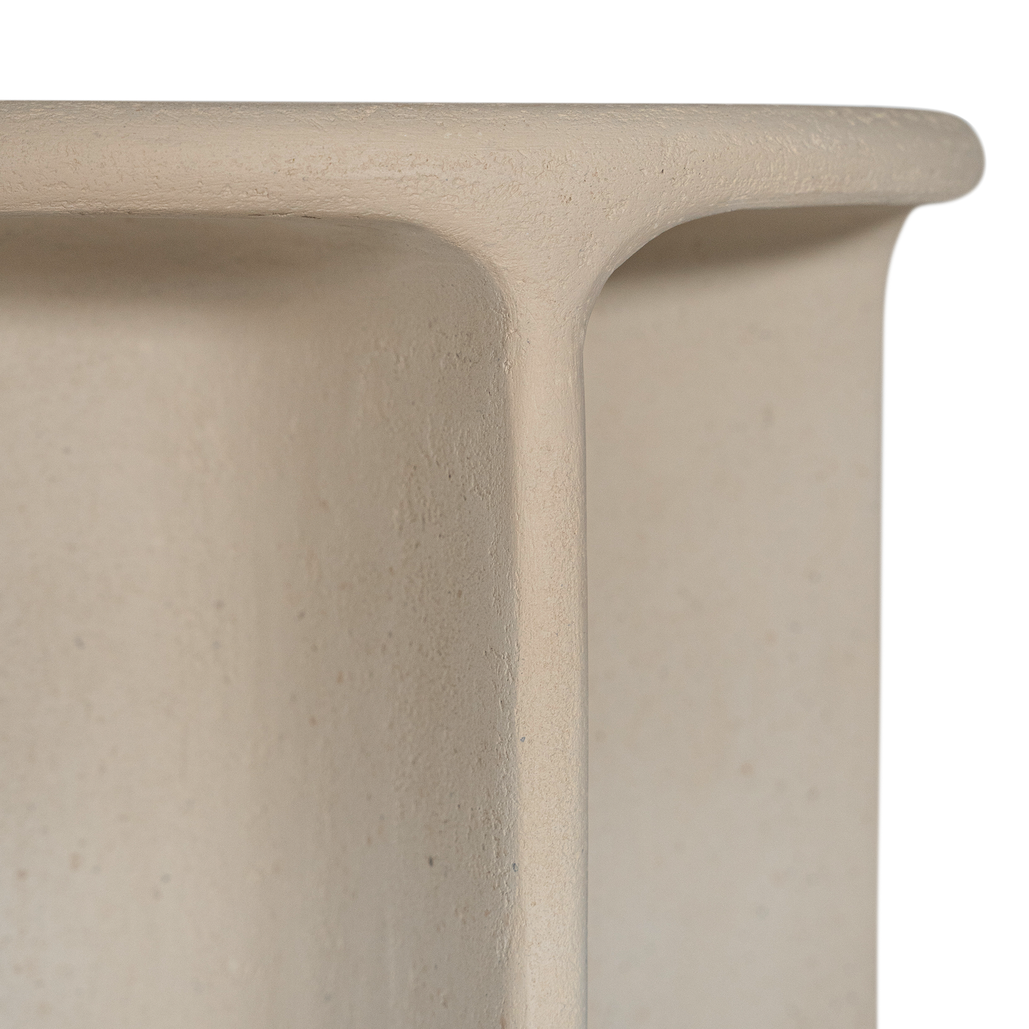 Berber side table in driftstone finish featuring sculptural curved legs and a softly rounded top with a textured natural surface.