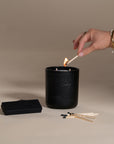 Kulala Living black matchbox with minimalist branding, featuring long wooden matches with black tips, set against a neutral backdrop for a refined aesthetic