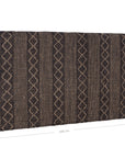 A black and natural handwoven bedhead featuring intricate geometric patterns, crafted from durable natural fibres for a timeless and earthy aesthetic