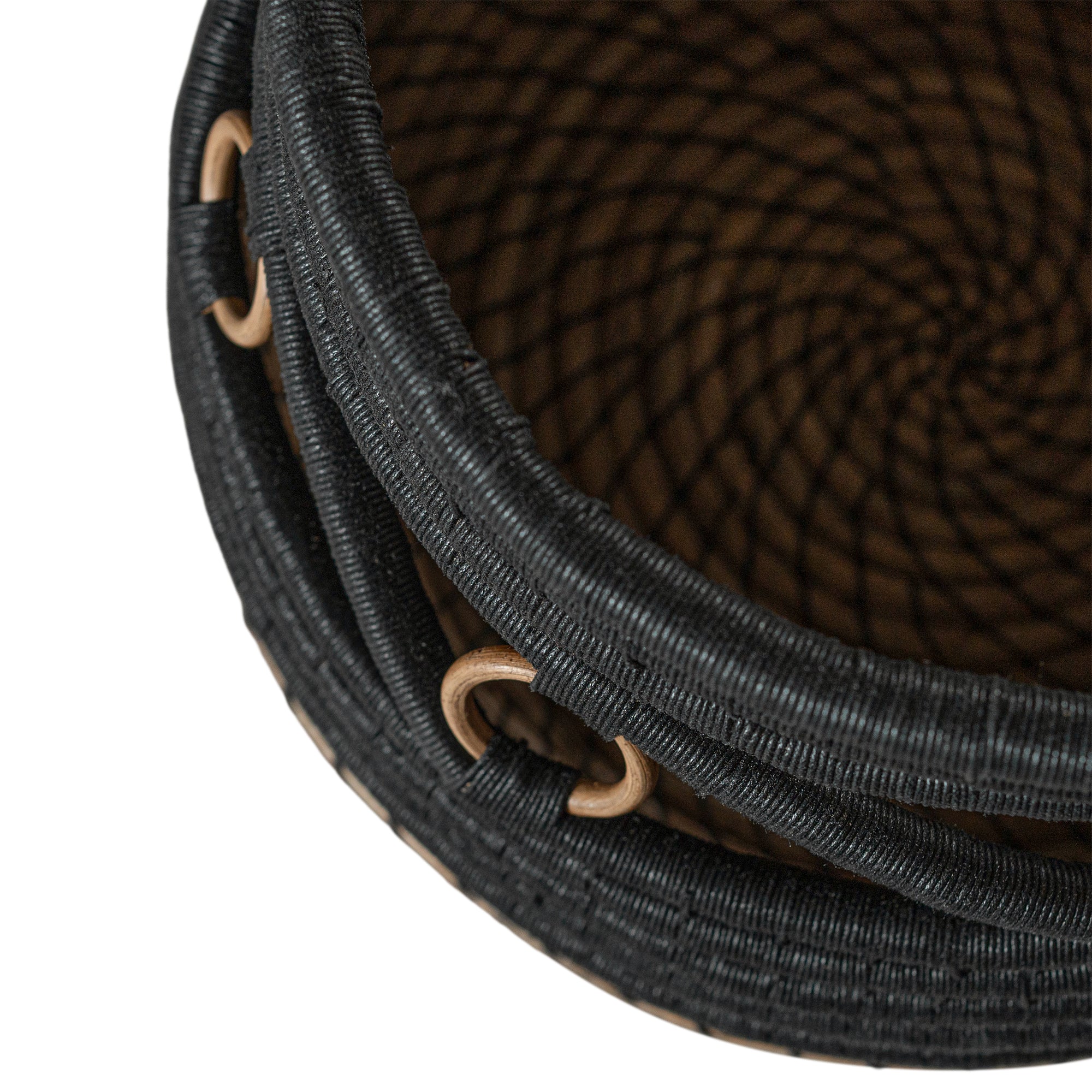 Black and natural woven basket with circular accents, ideal for decorative storage and adding texture to interior spaces.