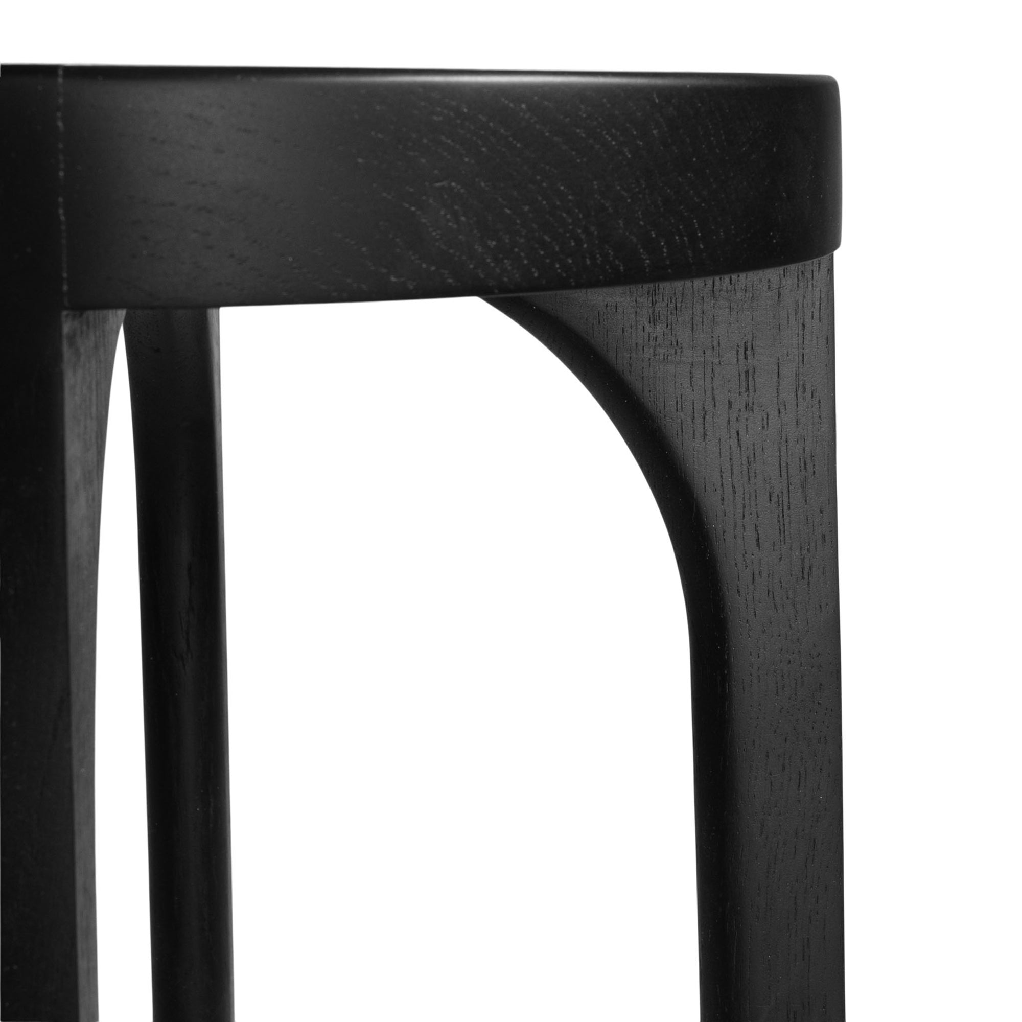A sleek black oak round stool featuring a minimalist design with subtly curved legs. Crafted from solid oak with a matte black finish, this versatile piece functions as a stool or side table, adding a modern touch to any space