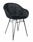 Black rattan dining chair with curved back and slim metal legs, perfect for modern and stylish dining settings