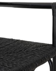 Black wicker armchair with armrests and a sturdy cross-frame base, showcasing a contemporary design suitable for indoor or outdoor dining spaces.