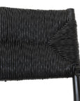 Black wicker armchair with armrests and a sturdy cross-frame base, showcasing a contemporary design suitable for indoor or outdoor dining spaces.