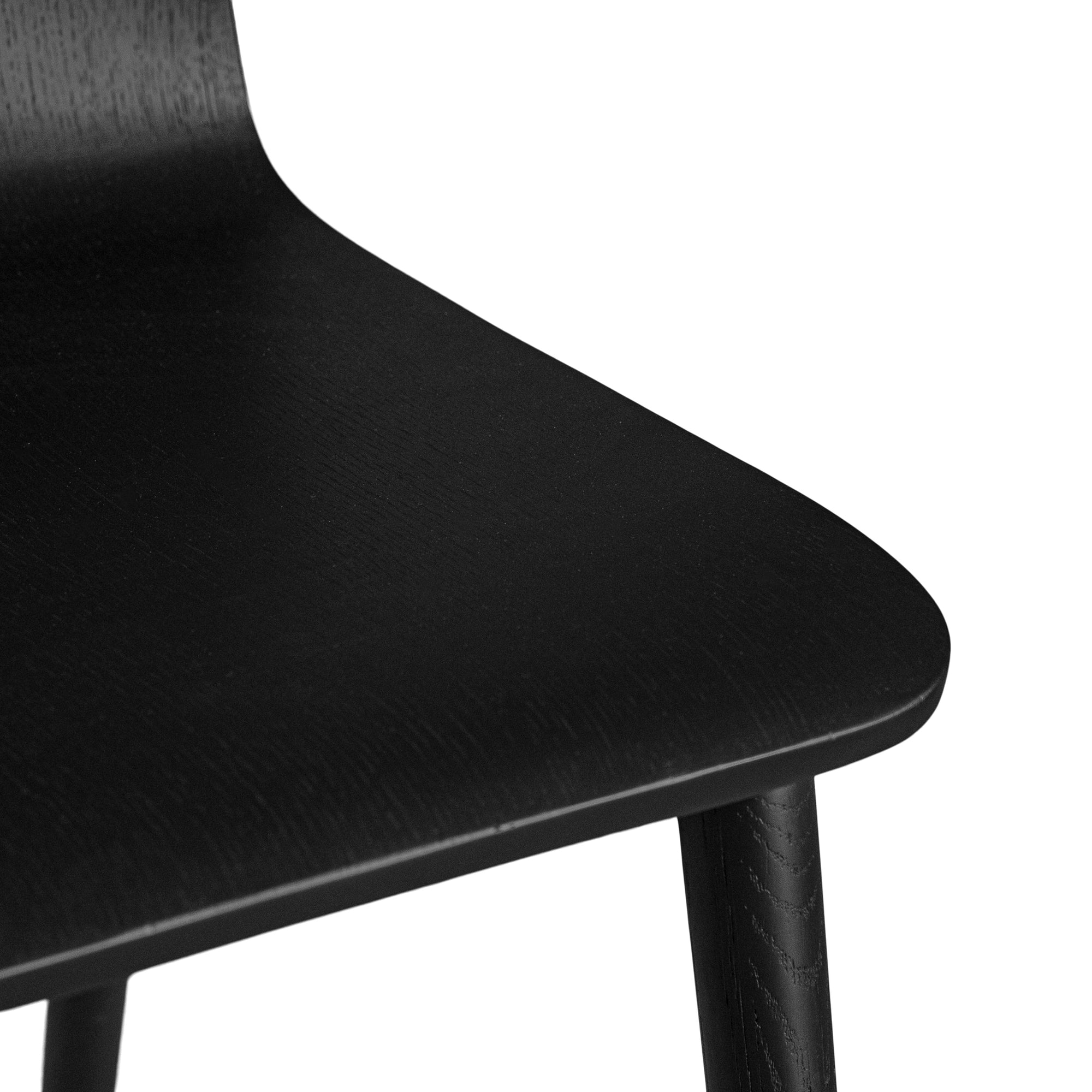 The Kulala Living black wood dining chair features a sleek, curved seat with a natural wood grain finish. Its minimalist design and sturdy legs make it a stylish and versatile addition to any modern dining space