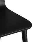 The Kulala Living black wood dining chair features a sleek, curved seat with a natural wood grain finish. Its minimalist design and sturdy legs make it a stylish and versatile addition to any modern dining space