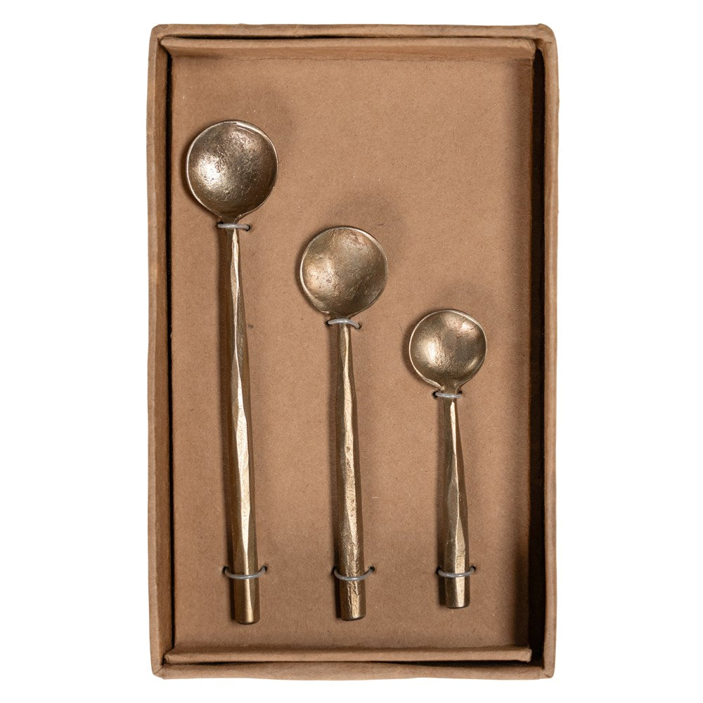 A set of three handcrafted brass spoons from KULALA Living, featuring an artisanal hammered finish and elegantly tapered handles, perfect for serving and stirring with style