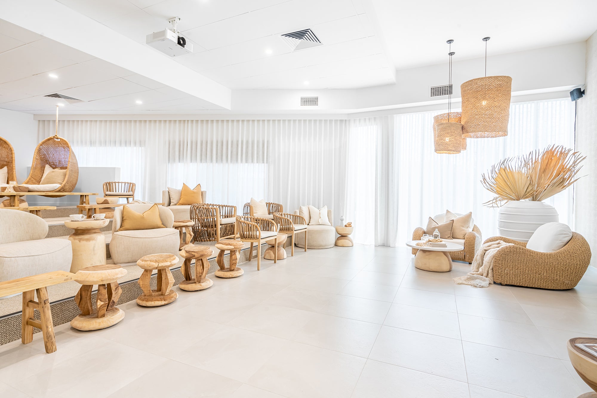 Coroo occasional chair in natural textured fabric with a soft curved backrest and rounded silhouette on a low plinth base.