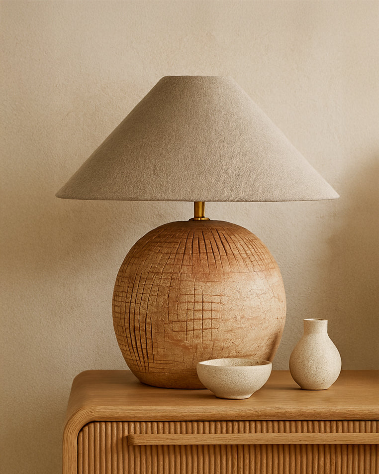 Debele clay table lamp with a natural linen shade styled on a timber bedside with ceramic decor in a warm neutral bedroom setting