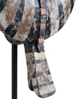 A striking decorative tribal horn sculpture with bold black and natural tones, mounted on a sleek black stand, adding an artisanal touch to modern interiors.