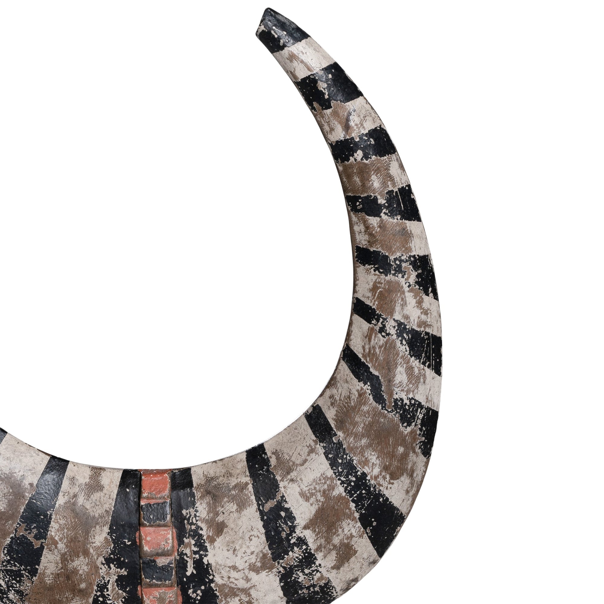 A striking decorative tribal horn sculpture with bold black and natural tones, mounted on a sleek black stand, adding an artisanal touch to modern interiors.