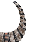 A striking decorative tribal horn sculpture with bold black and natural tones, mounted on a sleek black stand, adding an artisanal touch to modern interiors.